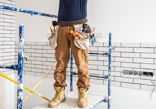Professional in overalls with tools on the background of the repair site.